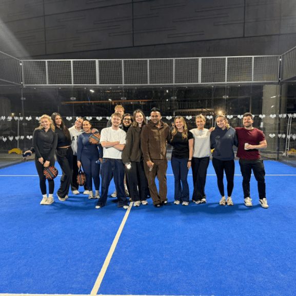 The team lined up on a blue padel court on a club night