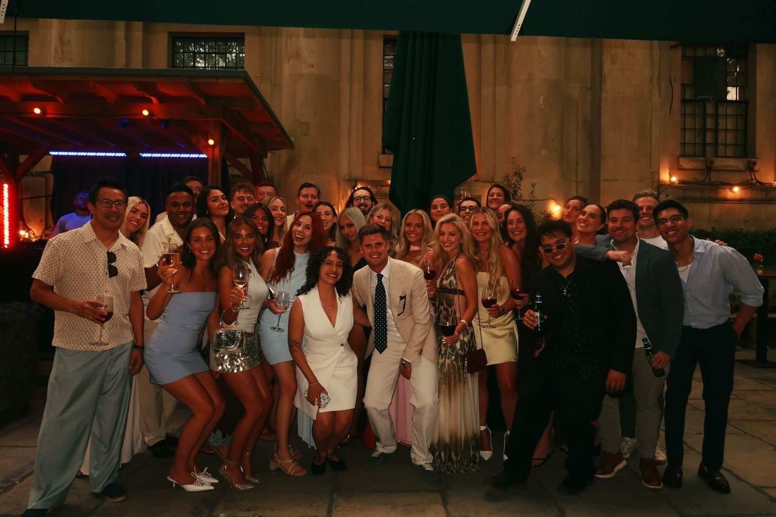 The whole Somerce team dressed up and gathered outside on a summer evening, drinks in hand