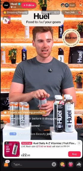 Huel TikTok LIVE: a host at a shelf-lit Huel set holding a bottle, with Daily A-Z Vitamins pinned below at £22