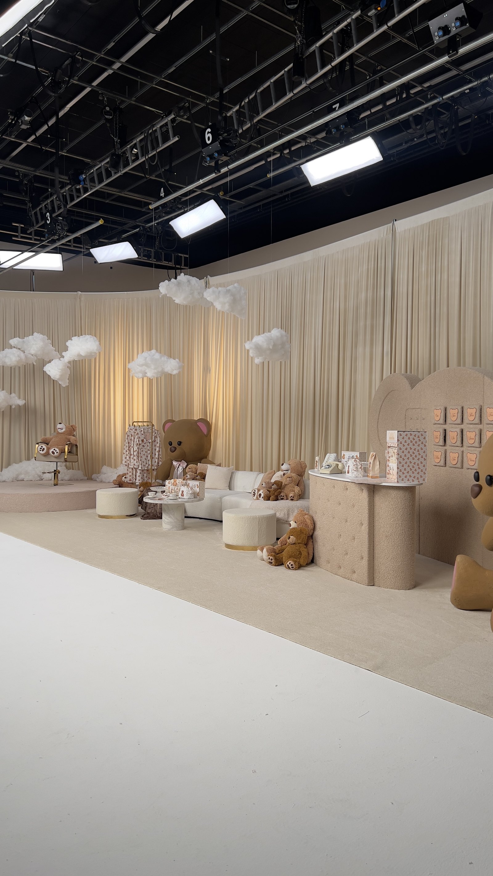 A fully dressed custom LIVE set with clouds, seating and a product wall