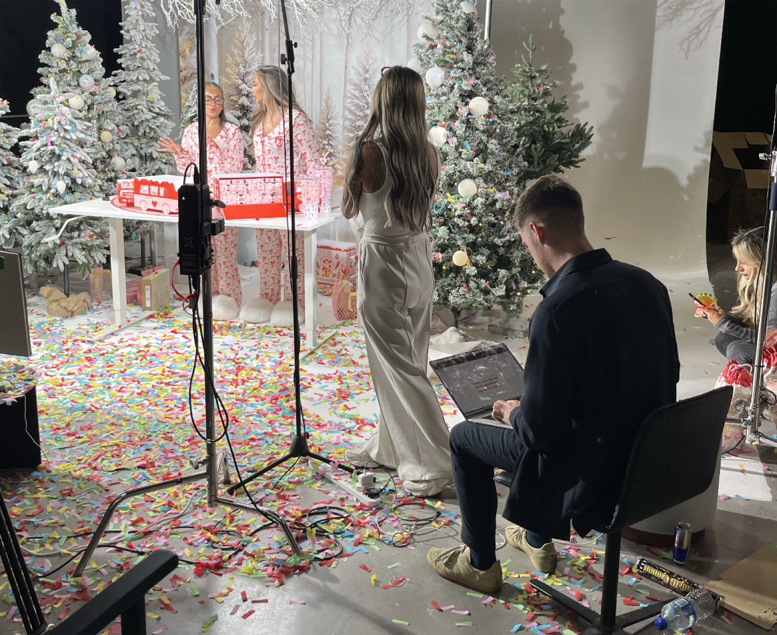 A producer running a LIVE from a laptop at the edge of a dressed festive set