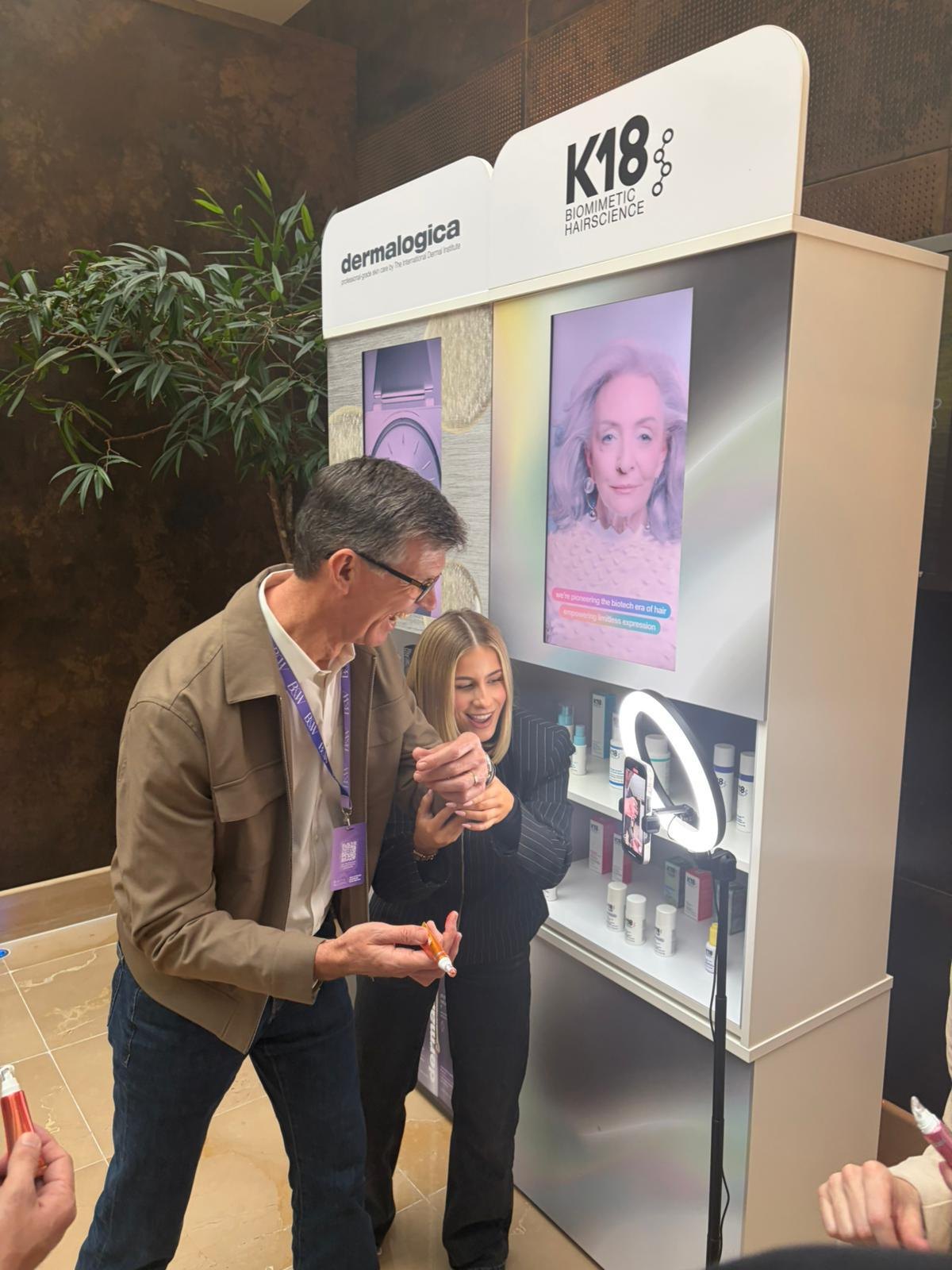 A hands-on product demo at a K18 and Dermalogica station, ring light rolling